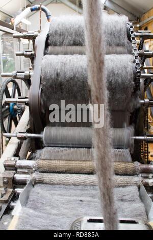 Wool thread being spun from raw wool product , part of process to create woll knitwear products in Woolen mill Stock Photo