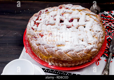 Delicious Homemade cherry Pie dusted with icing sugar on the plate on the dark old wooden table. Making cherry Pie Series, Stock Photo