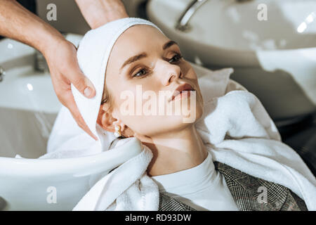 cropped shot of hairdresser washing hair to young woman in beauty salon Stock Photo