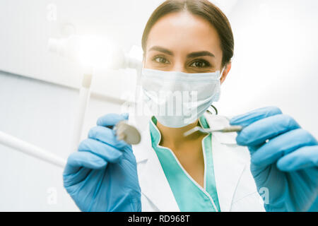 selective focus of female stomatologist holding instuments in hands Stock Photo