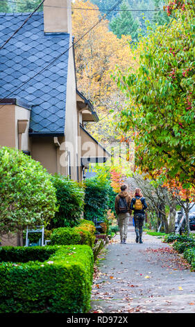 Young beautiful fashionable couple a boy and a girl in great shape are walking along the street of a modern city, enjoying the city landscapes and the Stock Photo