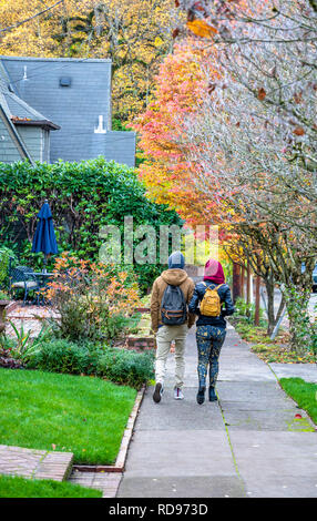 Young beautiful fashionable couple a boy and a girl in great shape are walking along the street of a modern city, enjoying the city landscapes and the Stock Photo