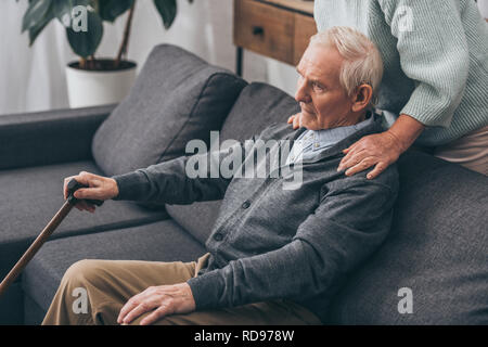 cropped view of senior wife hugging retired husband at home