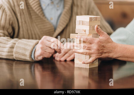 cropped view of senior couple playing jenga at home Stock Photo