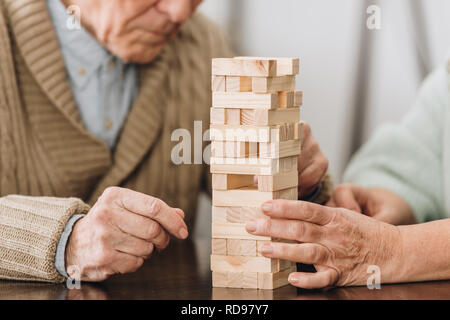 cropped view of retired couple playing jenga game at home Stock Photo