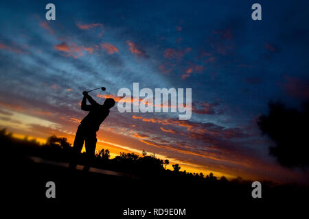 A silhouette of a golfer at the end of his stroke during sunset in Phoenix, Arizona. Stock Photo