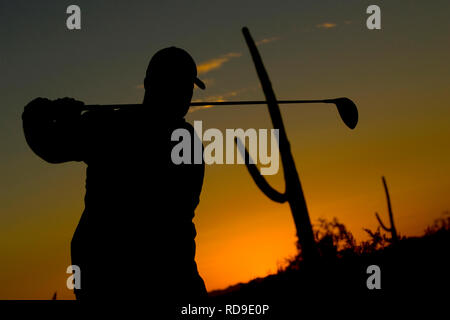 A silhouette of a golfer at the end of his stroke during sunset in Phoenix, Arizona. Stock Photo