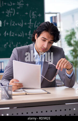 Young handsome math teacher in classroom Stock Photo
