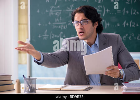 Young handsome math teacher in classroom Stock Photo