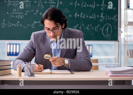 Young handsome math teacher in classroom Stock Photo