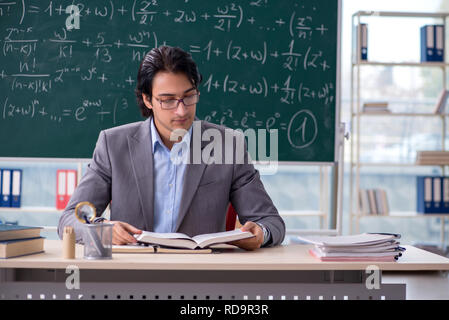 Young handsome math teacher in classroom Stock Photo