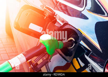 Refueling the car at a gas station fuel pump. Man driver hand refilling and pumping gasoline oil the car with fuel at he refuel station. Car refueling Stock Photo