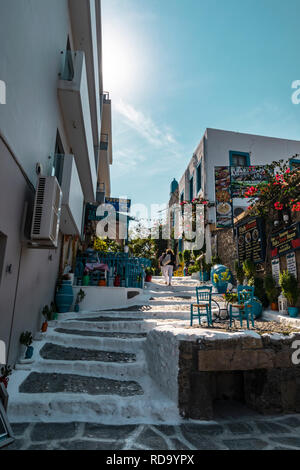Kos, Greece - October 11, 2018: View of a side street in the city centre of the Greek city of Kos with bars and cafe tables and chairs. Stock Photo