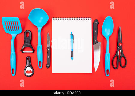 Top view of cooking utensils composition in kitchen isolated on red background Stock Photo