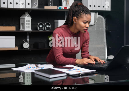 young African-American businesswoman working on laptop in office Stock Photo