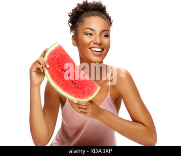 Lovely girl holding red ripe watermelon slice. Portrait of smiling african american girl isolated on white background. Healthy & Happy Stock Photo