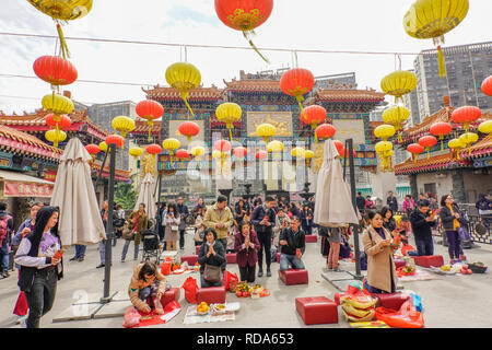 Worshippers at the Sik Sik Yuen Wong Tai Sin Temple Hong Kong. They light worshipers sticks at the altar before making a wish. Stock Photo