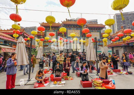 Worshippers at the Sik Sik Yuen Wong Tai Sin Temple Hong Kong. They light worshipers sticks at the altar before making a wish. Stock Photo