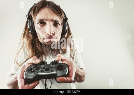 Lifestyle of young people. Student man spending time on playing games videogames console playstation. Long haired guy focus on gaming. Stock Photo