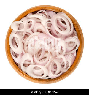 Rings of sliced shallots in wooden bowl. Chopped. Type of onion and variety of Allium cepa. Purple, edible, raw, organic, vegan, plant. Stock Photo