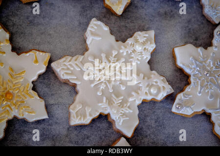 Christmas themed ginger bread snowflake biscuits with decorative embossed fondant icing Stock Photo