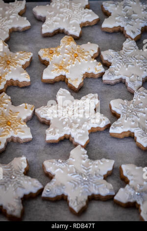Christmas themed ginger bread snowflake biscuits with decorative embossed fondant icing Stock Photo