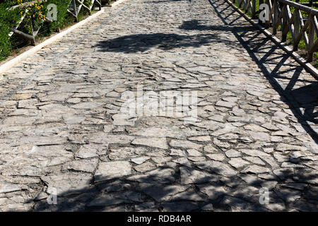 Rural cobblestone pavement with shadows in bright light. Stock Photo
