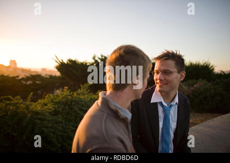 Smiling young man looking at his male friend. Stock Photo