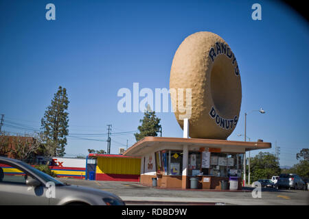Large plastic donut on the roof of a roadside shop in a small town. Stock Photo