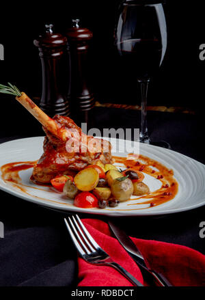 delicious restaurant dish, rack of lamb in restaurant background. Healthy exclusive food on big white platter closeup Stock Photo