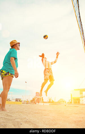 Volleyball beach player is a male athlete volleyball player getting ready to serve the ball on the beach. Stock Photo