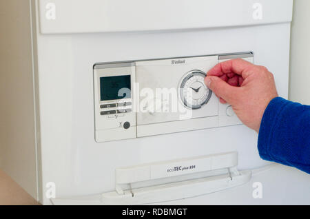 Caucasian Man Adjusting Setting or Clock on a Vaillant Combination Gas Central Heating Boiler, UK Stock Photo