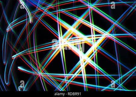 A colorful and glowing light painting abstract image with red, green, blue and yellow blurry lines over a black background, creating a net Stock Photo