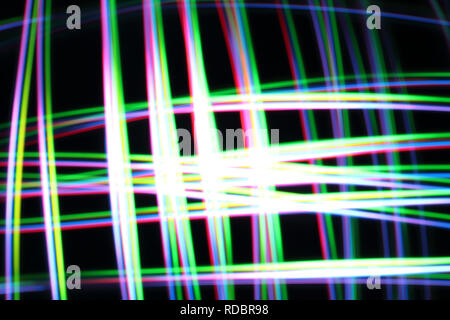 A colorful and glowing light painting abstract image with red, green, blue and yellow blurry lines over a black background, creating a net Stock Photo