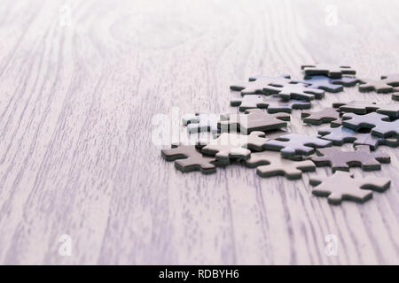 Puzzles on a white wooden table. Blurred background. Free space for the inscription Stock Photo