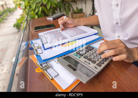 Man hand using calculator to check financial report Stock Photo