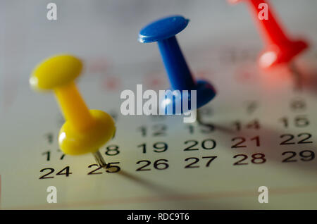 Embroidered blue pins on a calendar on the 25th with selective focus Stock Photo