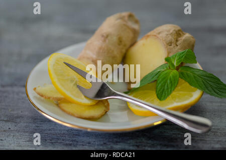 Lemons, mint and ginger on a white plate Stock Photo