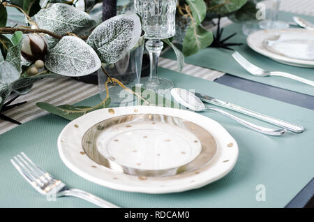 Table served for Christmas dinner. Festive place setting in green pastel tones. Christmas table setting in scandinavian style with natural decorations Stock Photo