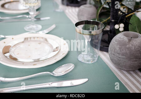 Table served for Christmas dinner. Festive place setting in green pastel tones. Christmas table setting in scandinavian style with natural decorations Stock Photo