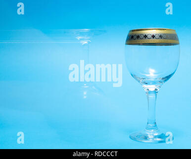 one empty and one ghost wine glasses on blue background Stock Photo