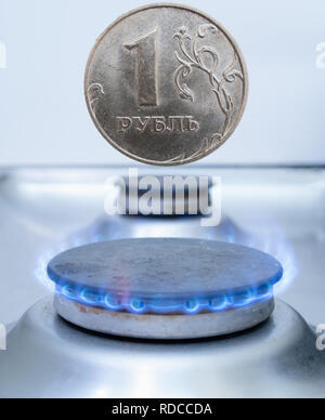 one russian coin ruble over gas burner. gazprom production industry, export or utility costs in russian federation concept Stock Photo