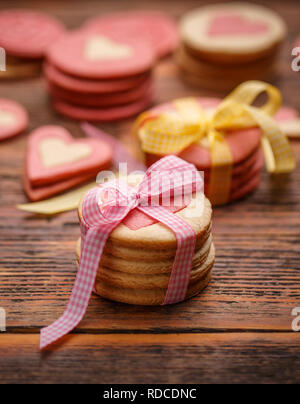 Cookies for Valentine's Day with pink ribbon on wooden table Stock Photo