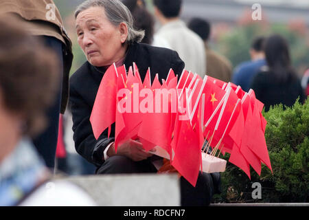 Lady selling Chinese Flags in Xian China Stock Photo