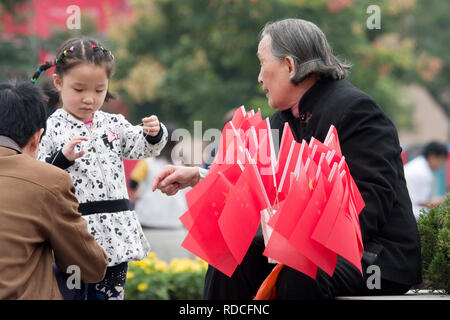 Lady selling Chinese Flags in Xian China Stock Photo