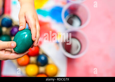 Child holding freshly colored Easter egg in his hands Stock Photo