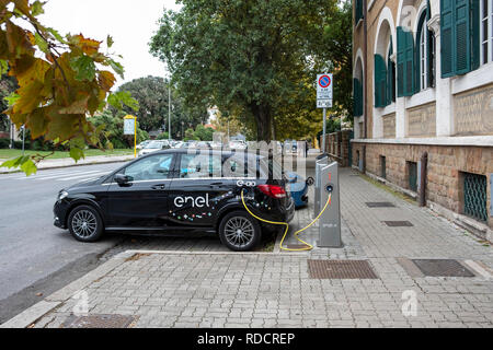 Electric Mercedes-Benz of E-Go car share service recharging on Enel X charging station in Ostia, a neighbourhood of Rome. Stock Photo