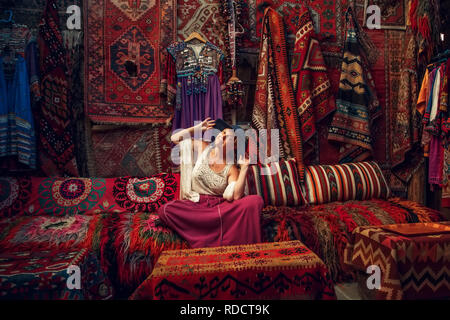 Girl in old carpet shop in Cappadocia, Goreme, Turkey. Stock Photo