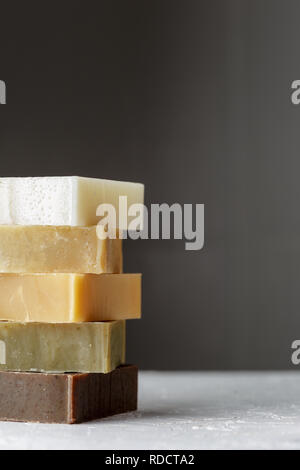 Tower stack of different kinds of handmade soaps over grey background Stock Photo