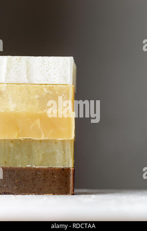Tower stack of different kinds of handmade soaps over grey background Stock Photo